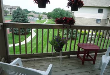 a deck with chairs and potted plants on it